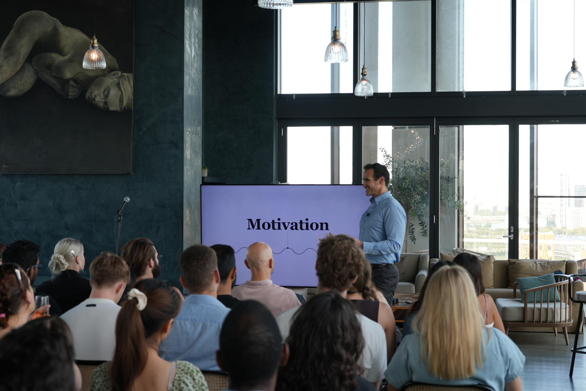 Speaker presenting 'Motivation' to a full Rebel Book Club room