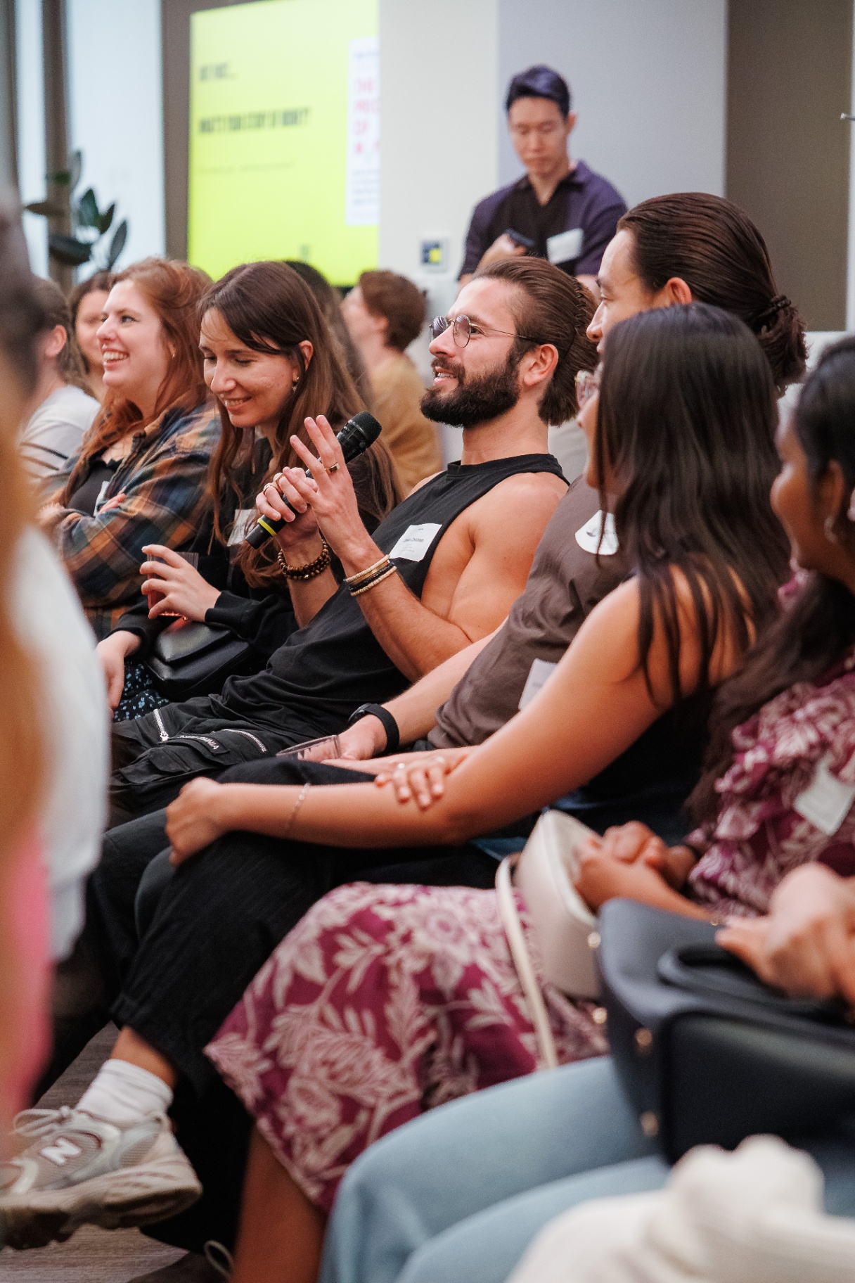 Member with a microphone asking a question during a Rebel Book Club talk